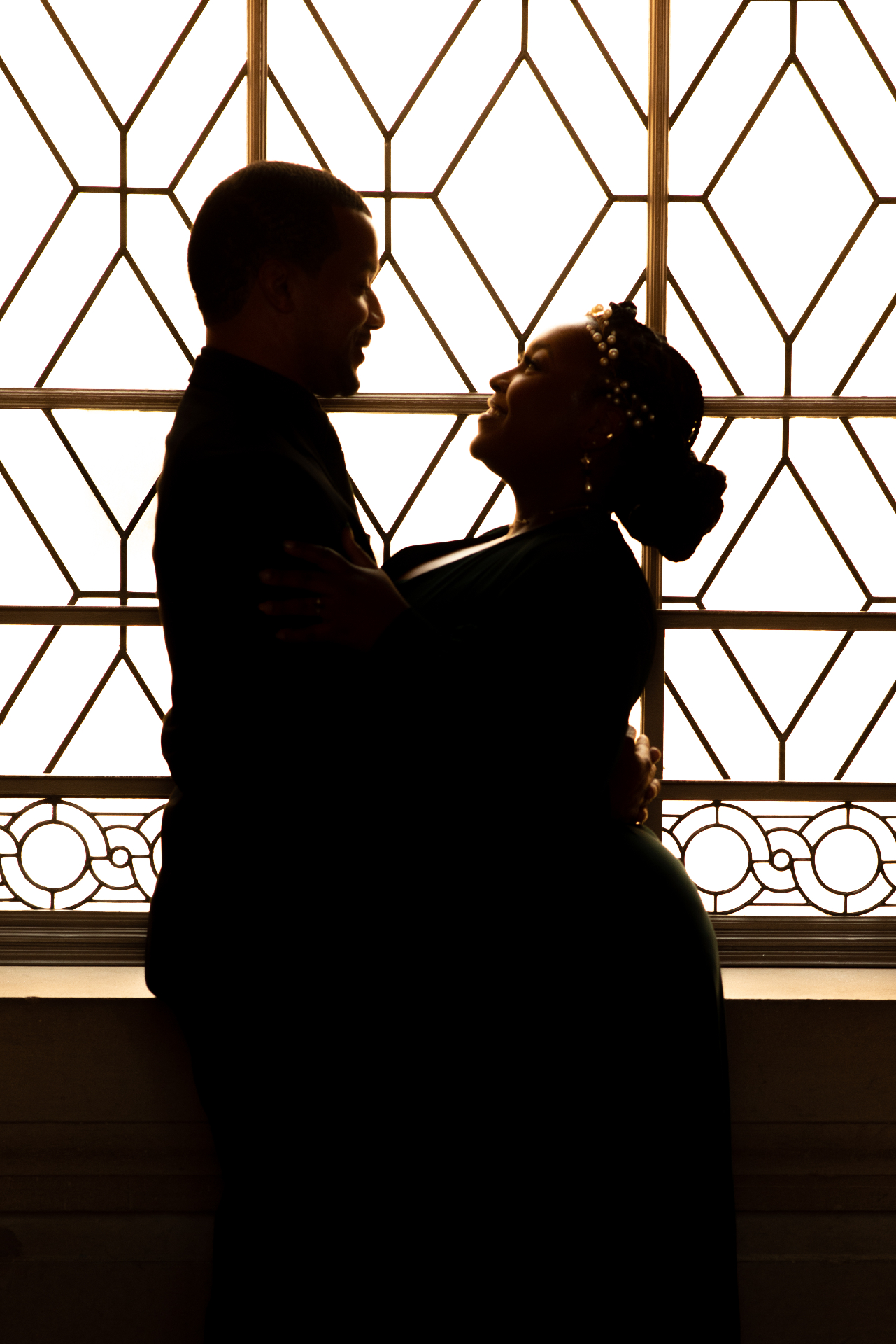 Artistic couple silhouette against geometric window